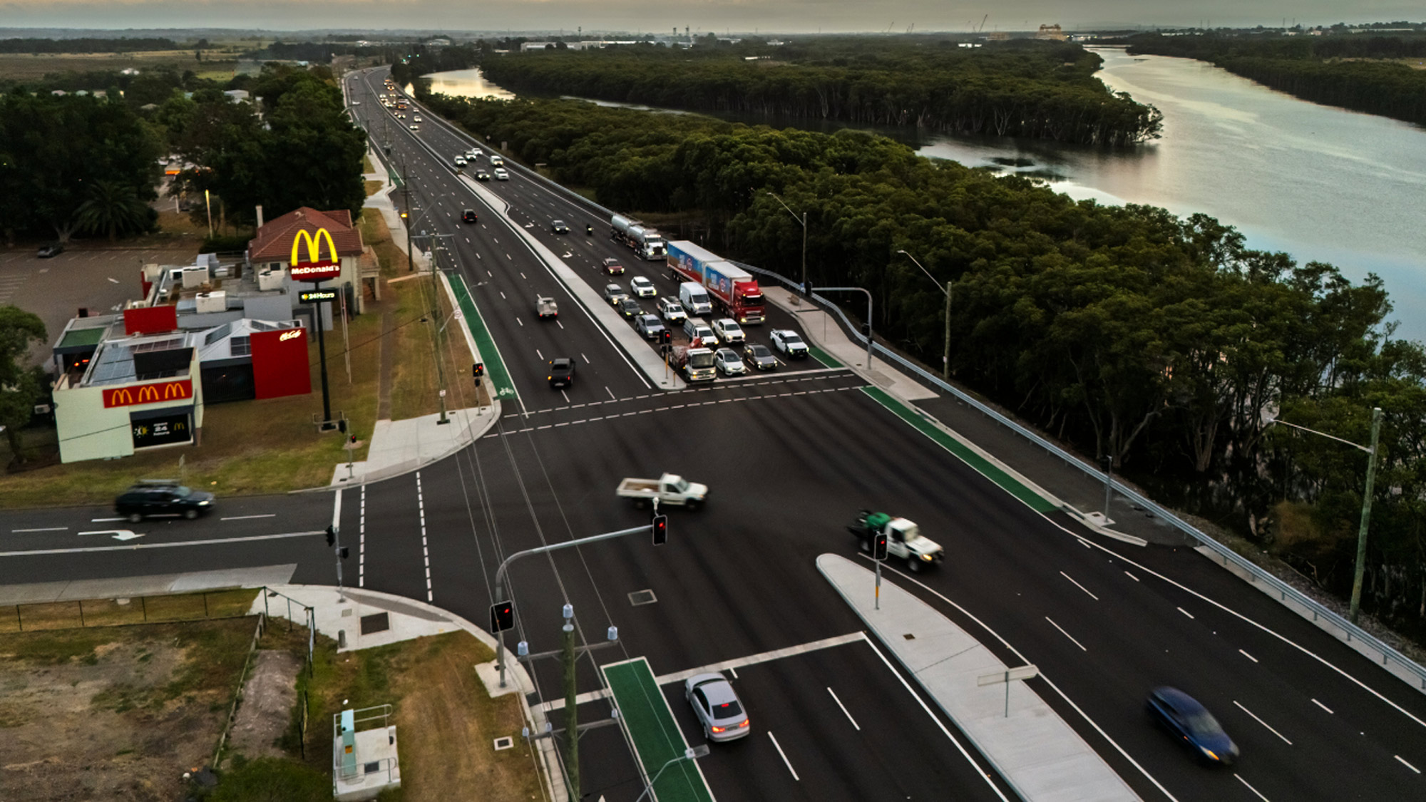 Aerial view of a multi-lane highway bridge crossing a winding river and wetlands in Hexham.