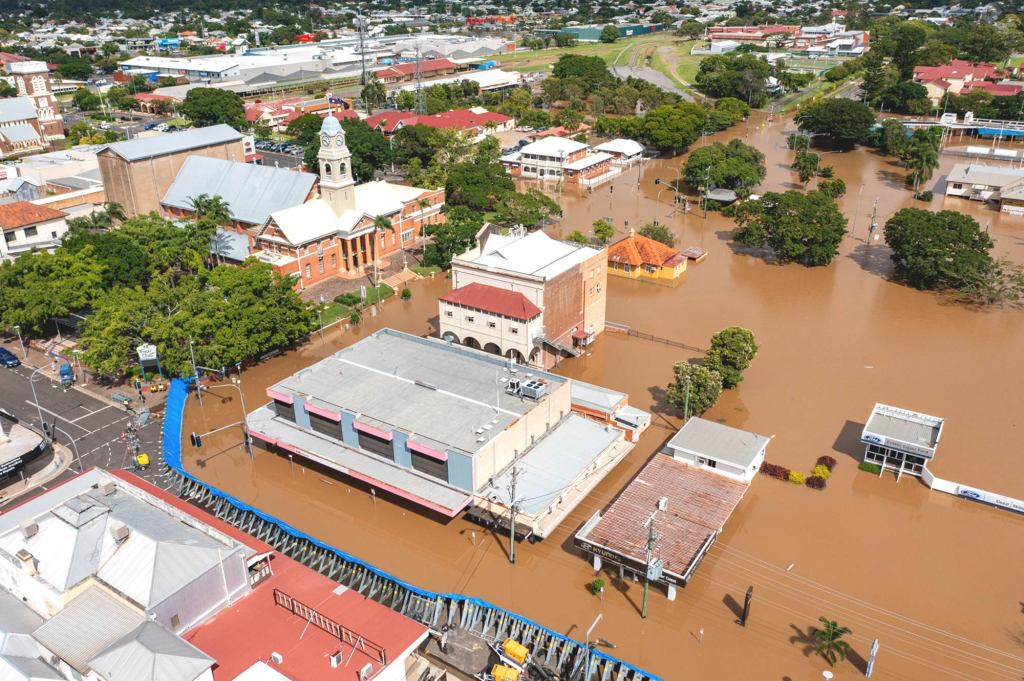 Aerial view of the Maryborough flood levee protecting part of the town while surrounding streets and buildings experience high floodwater levels.